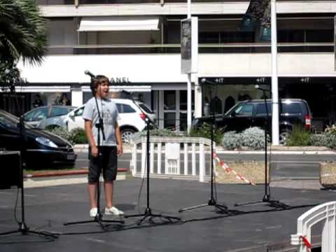 Young boy with fantastic voice singing near Palais des Festivals in Cannes,