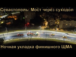 Строительство моста через суходол в Севастополе. Укладка финишного слоя асфальтобетона.